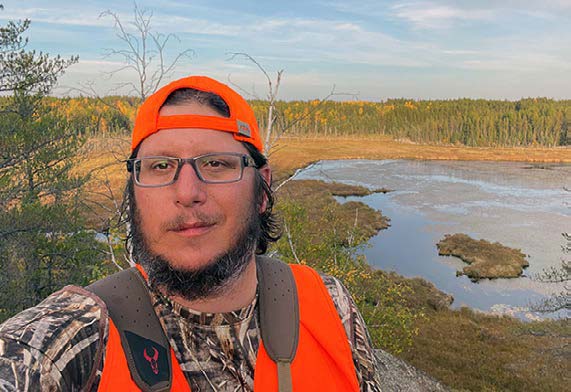 Moose hunter standing in a promising spot for the hunt