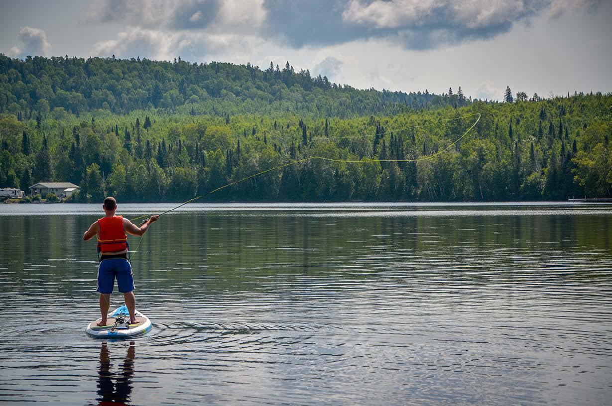 Author casting on a stand-up paddleboard