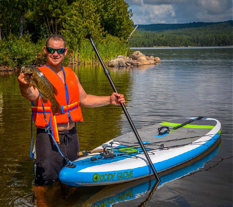 Author poses with walleye next to SUP used for fishing