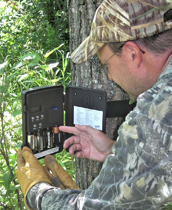 hunter replacing batteries in one of his older trail cams