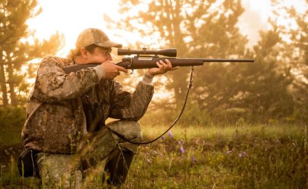 Hunter aiming a rifle with a scope