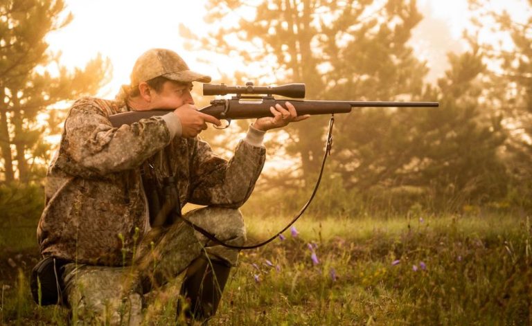 Hunter aiming a rifle with a scope