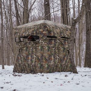 Camouflage hunting blind in a snowy forest.